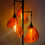 Arise Arbor Floor Lamp, black base with amber orange shades lit