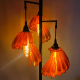 Arise Arbor Floor Lamp, black base with amber orange shades lit