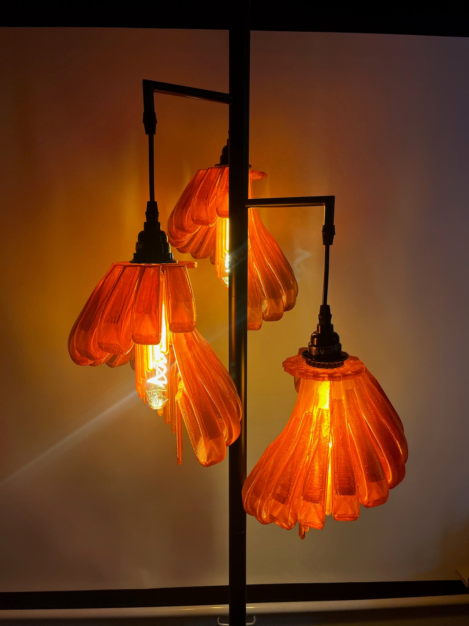 Arise Arbor Floor Lamp, black base with amber orange shades lit